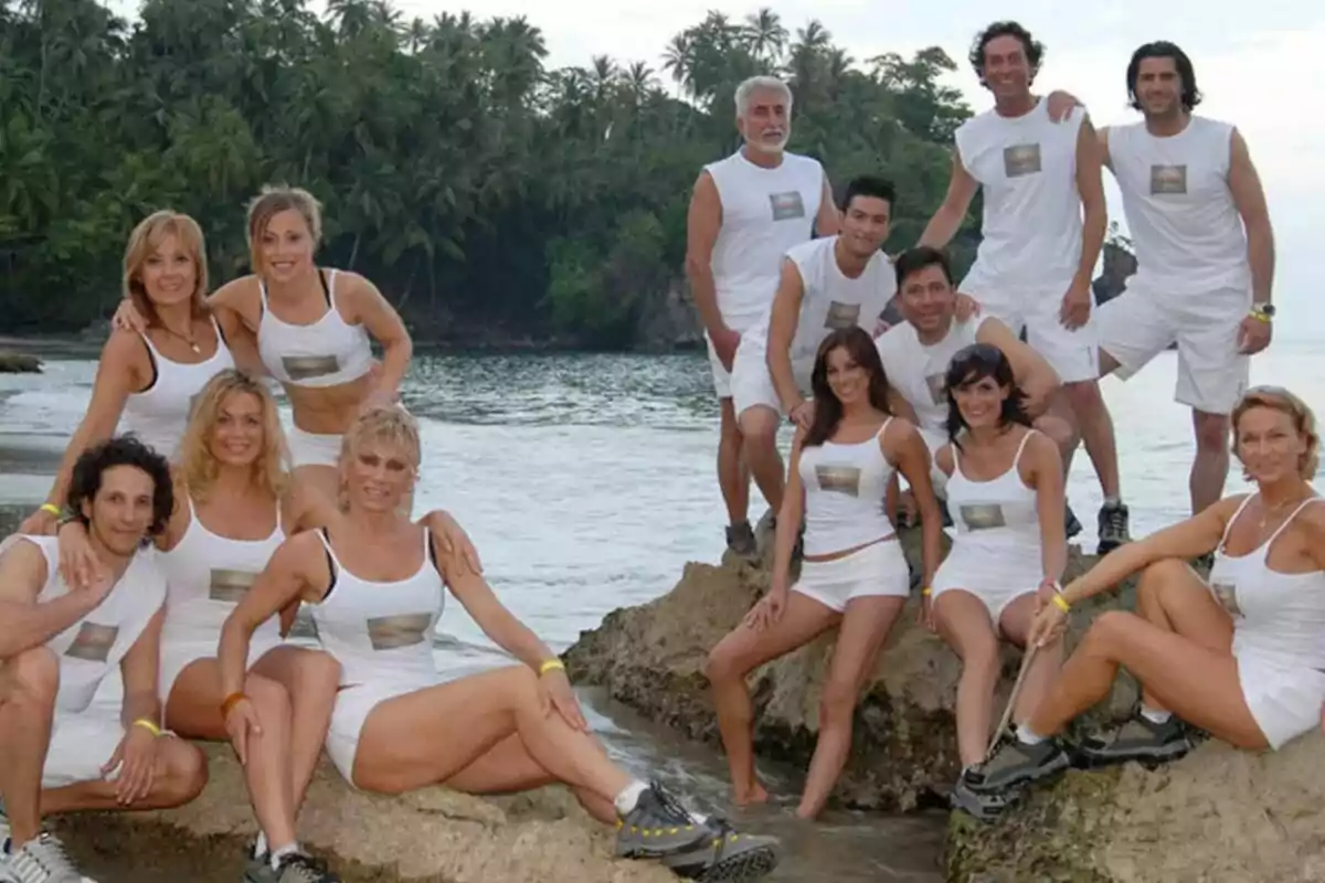 Un grup de persones vestides de blanc posant sobre roques al costat del mar amb un fons de palmeres a 'Supervivientes 2006'