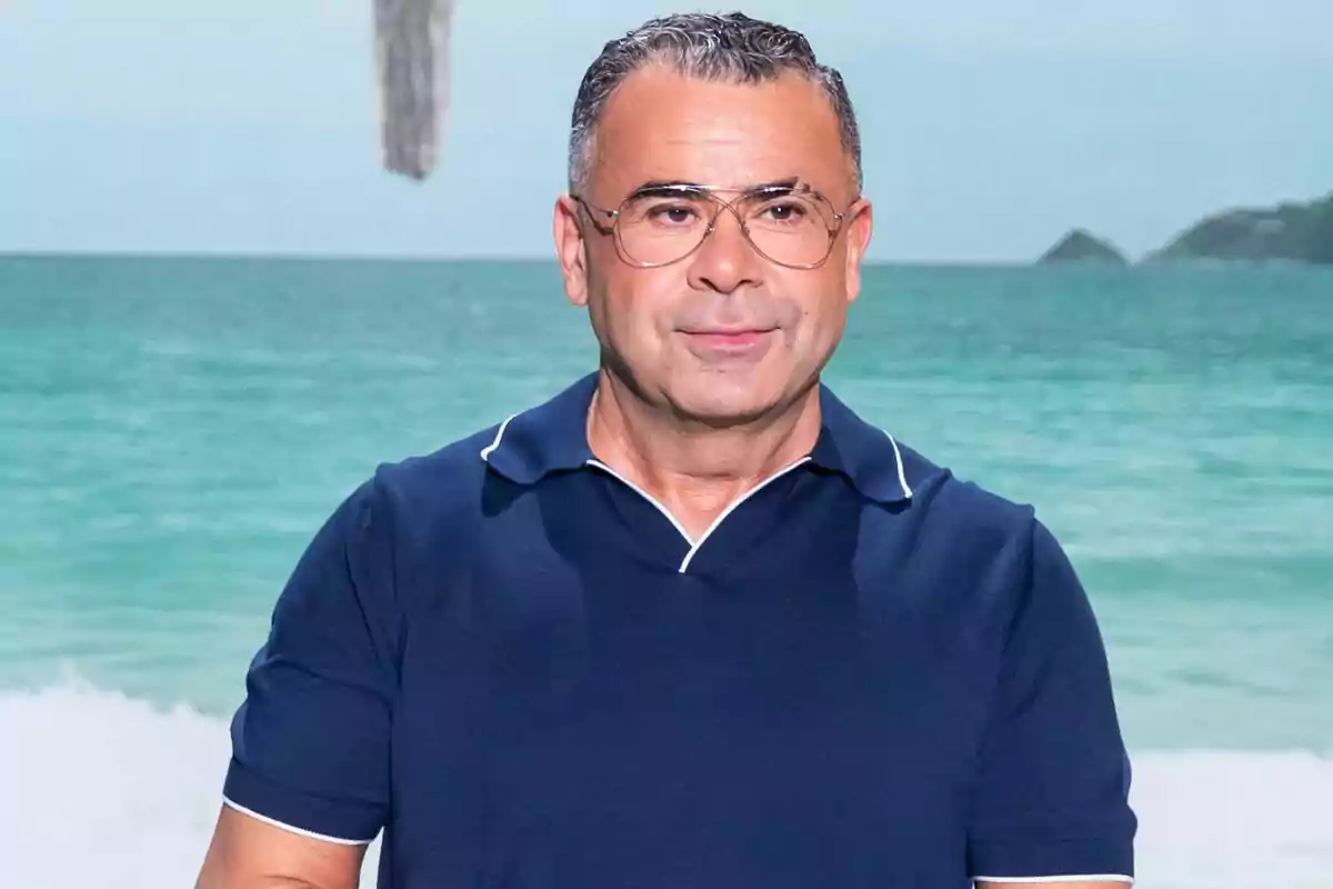 Jorge Javier Vázquez de cabello corto y gafas con camisa azul posando frente al mar en la rueda de prensa de 'Supervivientes'.
