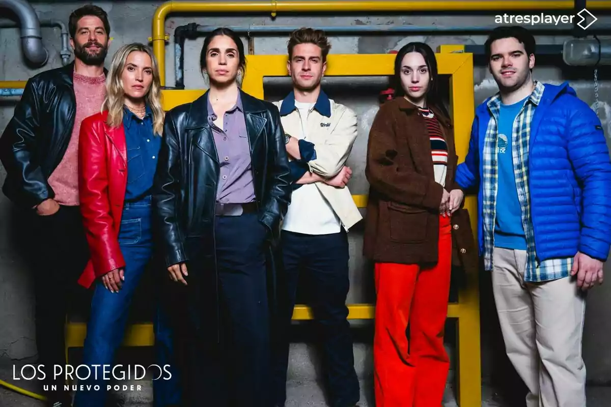 Ana Fernández, Luis Fernández, Mario Marzo, Elena Furiase, Daniel Avilés i Maggie García posen juntes davant d’una paret grisa amb canonades grogues, totes vestides amb roba casual i abrics de colors vius, sota el logotip d’una sèrie anomenada Els Protegits Un Nou Poder i el logotip d’atresplayer a la cantonada superior dreta. Ana Fernández, Luis Fernández, Mario Marzo, Elena Furiase, Daniel Avilés i Maggie García posen juntes davant d’una paret grisa amb canonades grogues, totes vestides amb roba casual i abrics de colors vius, sota el logotip d’una sèrie anomenada Els Protegits Un Nou Poder i el logotip d’atresplayer a la cantonada superior dreta.