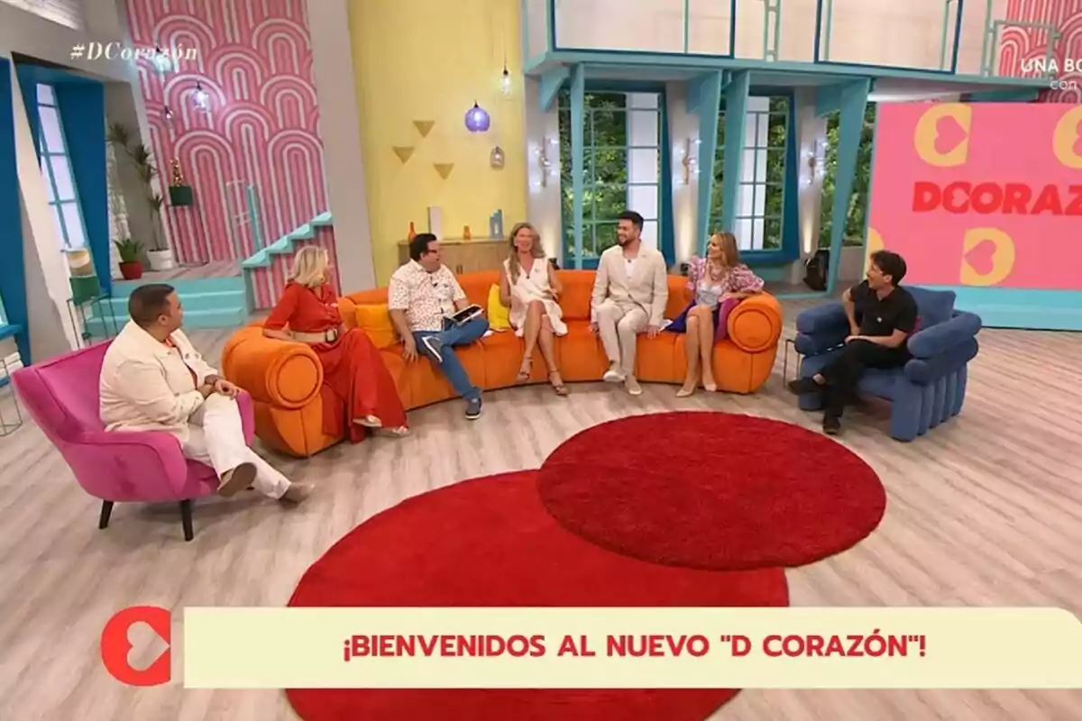 Un grupo de personas formado por David Insua, Marina Bernal, Alberto Guzmán, Anne Igartiburu, Javier de Hoyos, Alba Carrillo y Arnau Martínez conversa en un colorido set de televisión con sillones de colores y una alfombra roja, al fondo se ve una pantalla con el texto D Corazón y decoración moderna Un grupo de personas formado por David Insua, Marina Bernal, Alberto Guzmán, Anne Igartiburu, Javier de Hoyos, Alba Carrillo y Arnau Martínez conversa en un colorido set de televisión con sillones de colores y una alfombra roja, al fondo se ve una pantalla con el texto D Corazón y decoración moderna