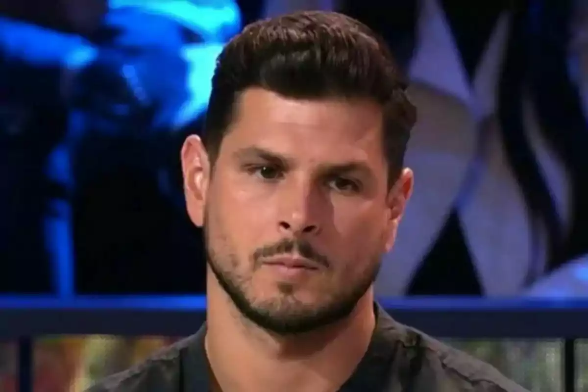 Alejandro Nieto de cabell fosc i barba curta amb expressió seriosa en un estudi de televisió de Supervivientes