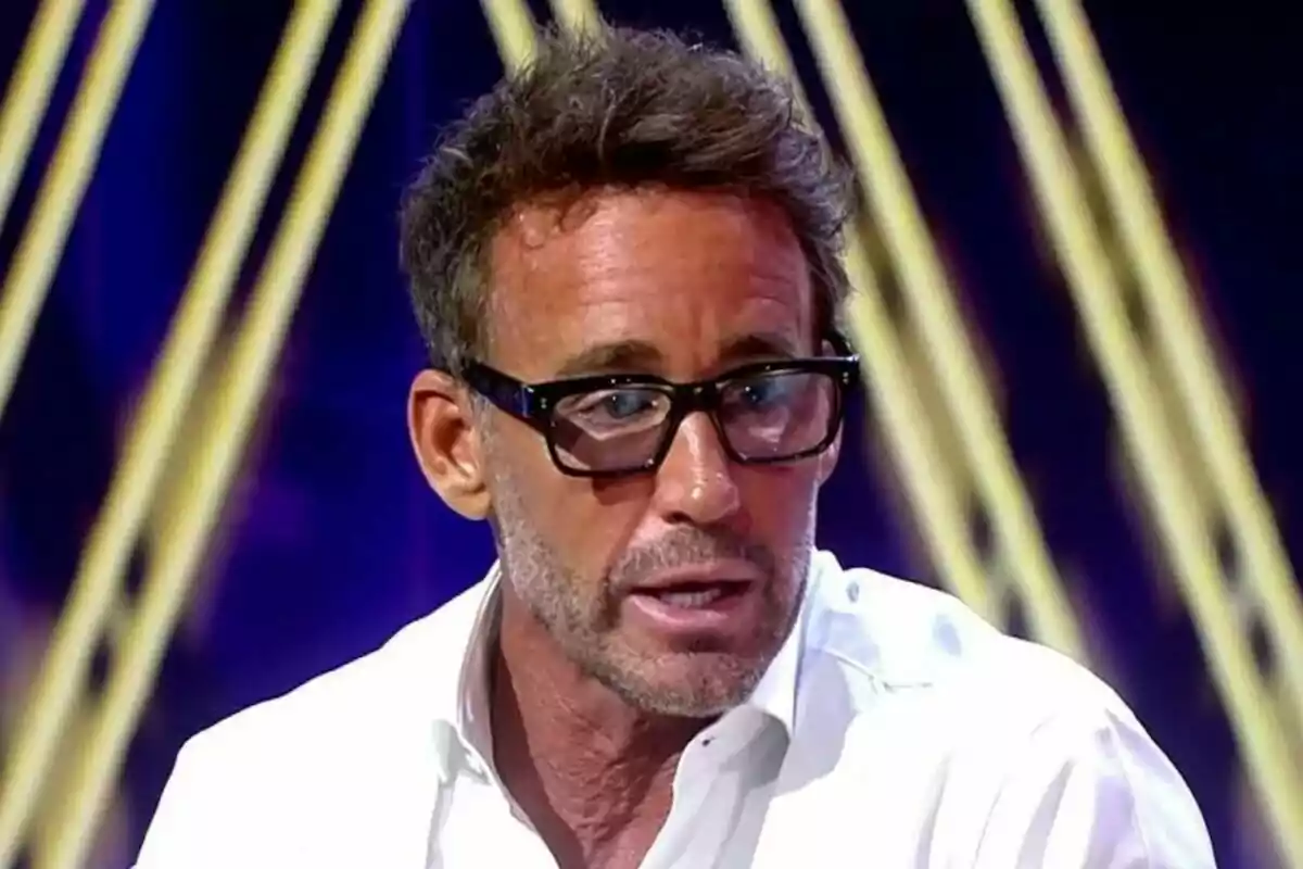 Álvaro Muñoz Escassi amb ulleres negres i camisa blanca parlant en un plató de De Divendres amb llums de fons Álvaro Muñoz Escassi amb ulleres negres i camisa blanca parlant en un plató de De Divendres amb llums de fons
