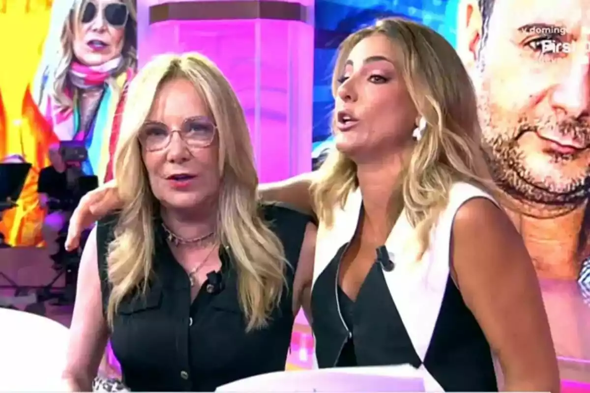 Belén Rodríguez i Verónica Dulanto, rosses, estan assegudes en un plató de Tardear amb pantalles colorides de fons; una d’elles porta ulleres i ambdues semblen estar conversant animadament.
