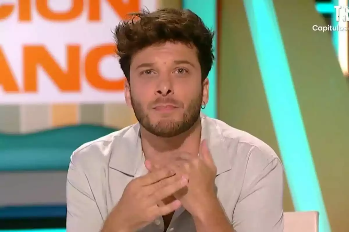 Blas Cantó jove amb barba i cabell arrissat mira al front mentre està assegut en un plató de Zapeando colorit Blas Cantó jove amb barba i cabell arrissat mira al front mentre està assegut en un plató de Zapeando colorit