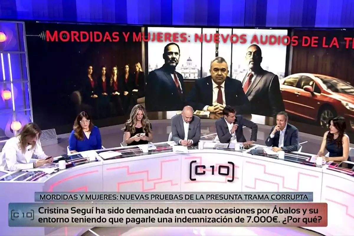 Un grup de persones com Cristina Seguí, Nacho Abad i David Aleman participa en un debat televisiu en un estudi modern de Codi 10, amb una gran pantalla al fons que mostra imatges d’homes amb vestit i un cotxe vermell, al costat d’un titular sobre àudios i una trama corrupta. Un grup de persones com Cristina Seguí, Nacho Abad i David Aleman participa en un debat televisiu en un estudi modern de Codi 10, amb una gran pantalla al fons que mostra imatges d’homes amb vestit i un cotxe vermell, al costat d’un titular sobre àudios i una trama corrupta.
