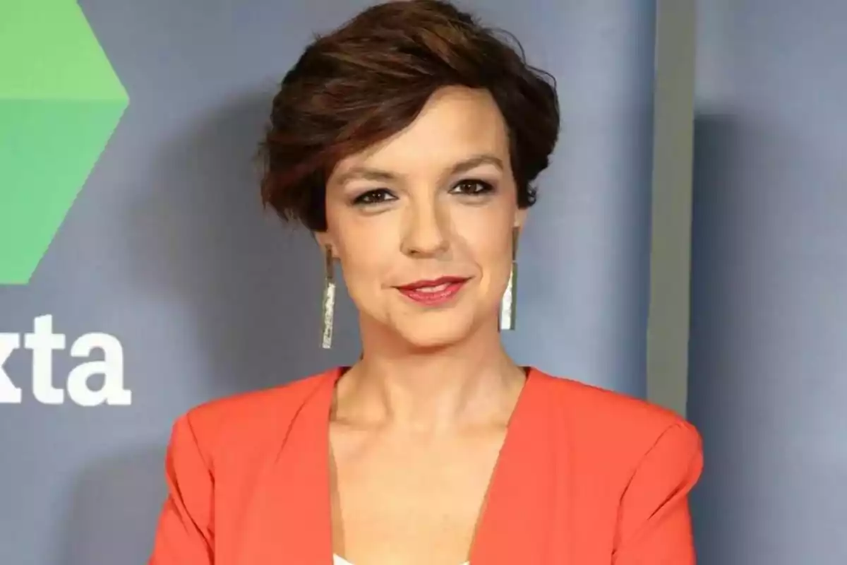 Cristina Villanueva de cabell curt castany amb arracades llargues i jaqueta taronja posant davant d’un fons gris amb part d’un logotip verd i lletres blanques de laSexta Notícies. Cristina Villanueva de cabell curt castany amb arracades llargues i jaqueta taronja posant davant d’un fons gris amb part d’un logotip verd i lletres blanques de laSexta Notícies.