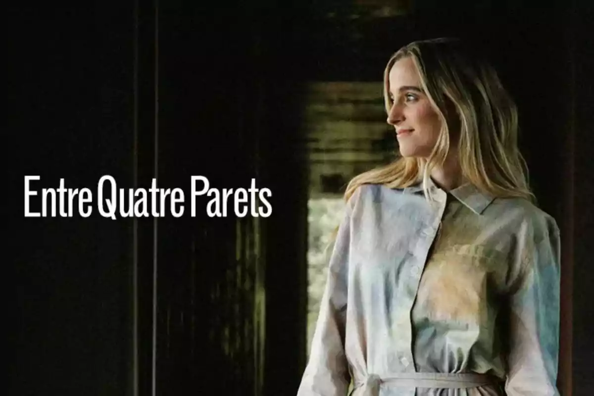 Núria Moliner rubia con vestido claro mira hacia la derecha junto al texto Entre Quatre Parets sobre un fondo oscuro
