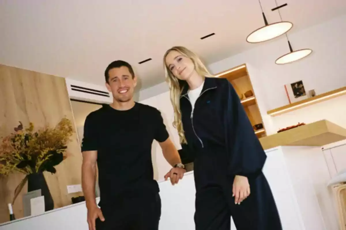 Núria Moliner y Bojan Krki posan sonrientes en una cocina moderna con decoración minimalista y luz cálida en Entre quatre parets. Núria Moliner y Bojan Krki posan sonrientes en una cocina moderna con decoración minimalista y luz cálida en Entre quatre parets.