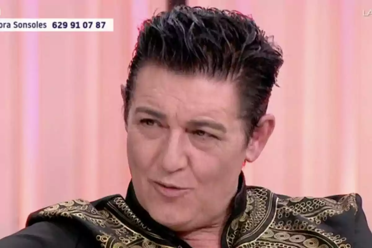 Ángel Garó de cabello oscuro peinado hacia atrás con chaqueta negra decorada con bordados dorados en un set de Y ahora Sonsoles con fondo claro