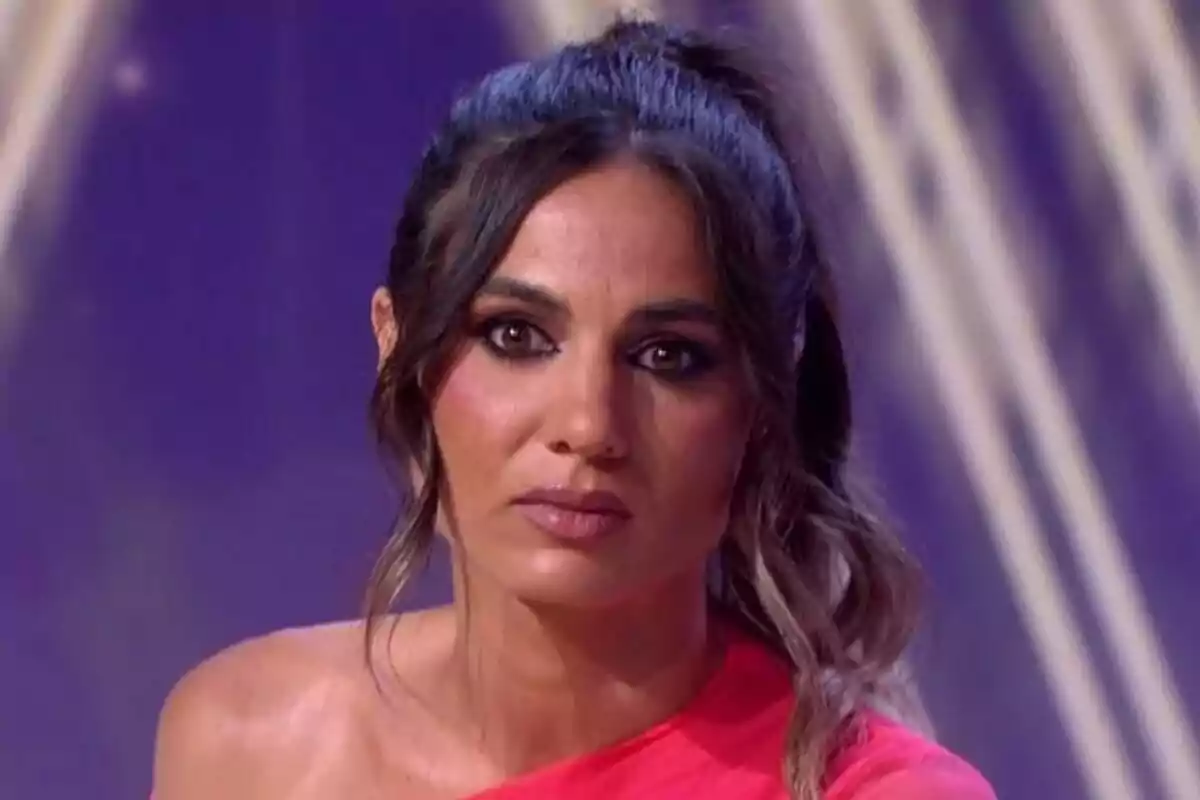 Gema Aldón de cabello oscuro recogido con expresión seria y fondo desenfocado en tonos morados en De Viernes