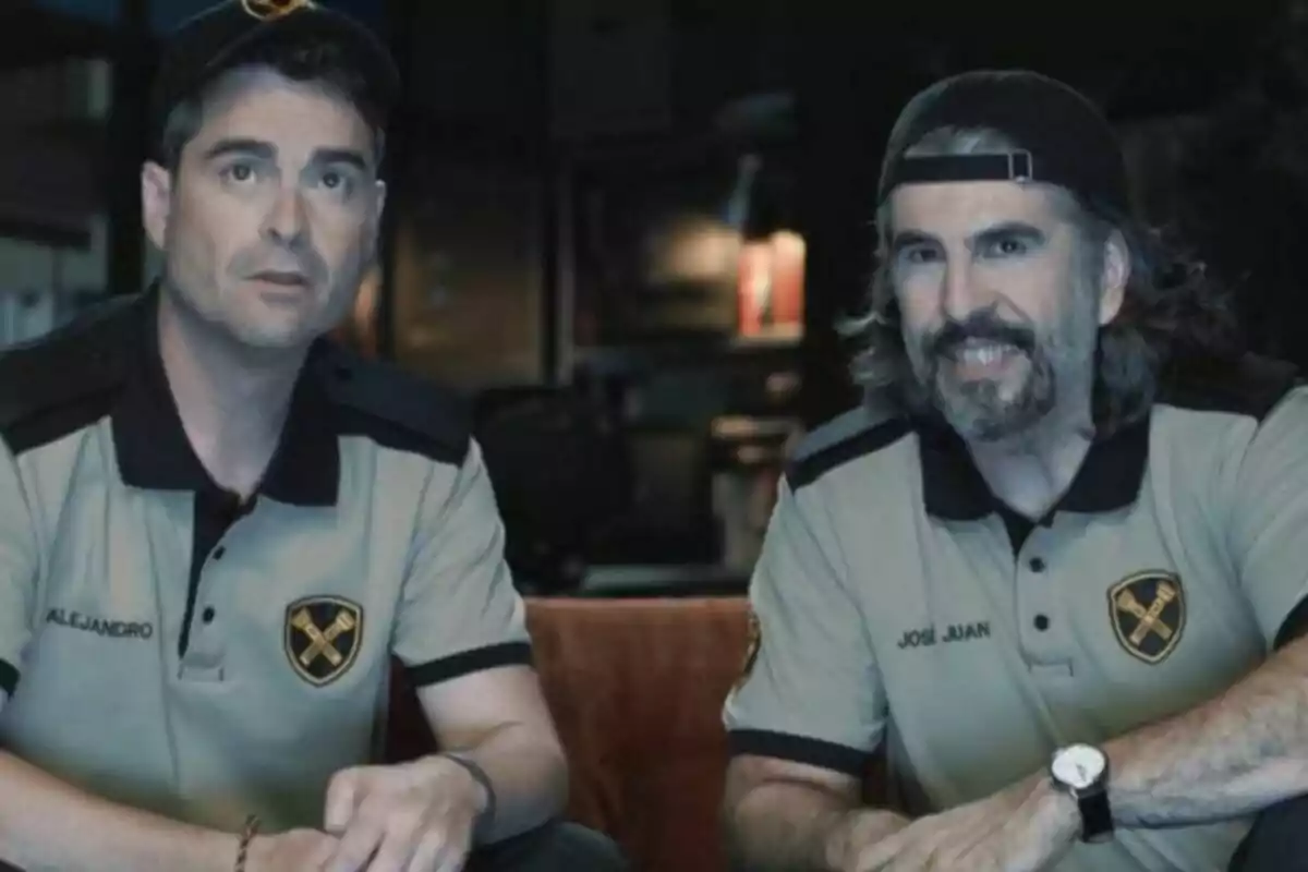 JJ Vaquero y Álex Clavero con uniforme beige y negro, sentados juntos y sonriendo, en un ambiente interior con luz tenue en La Garita