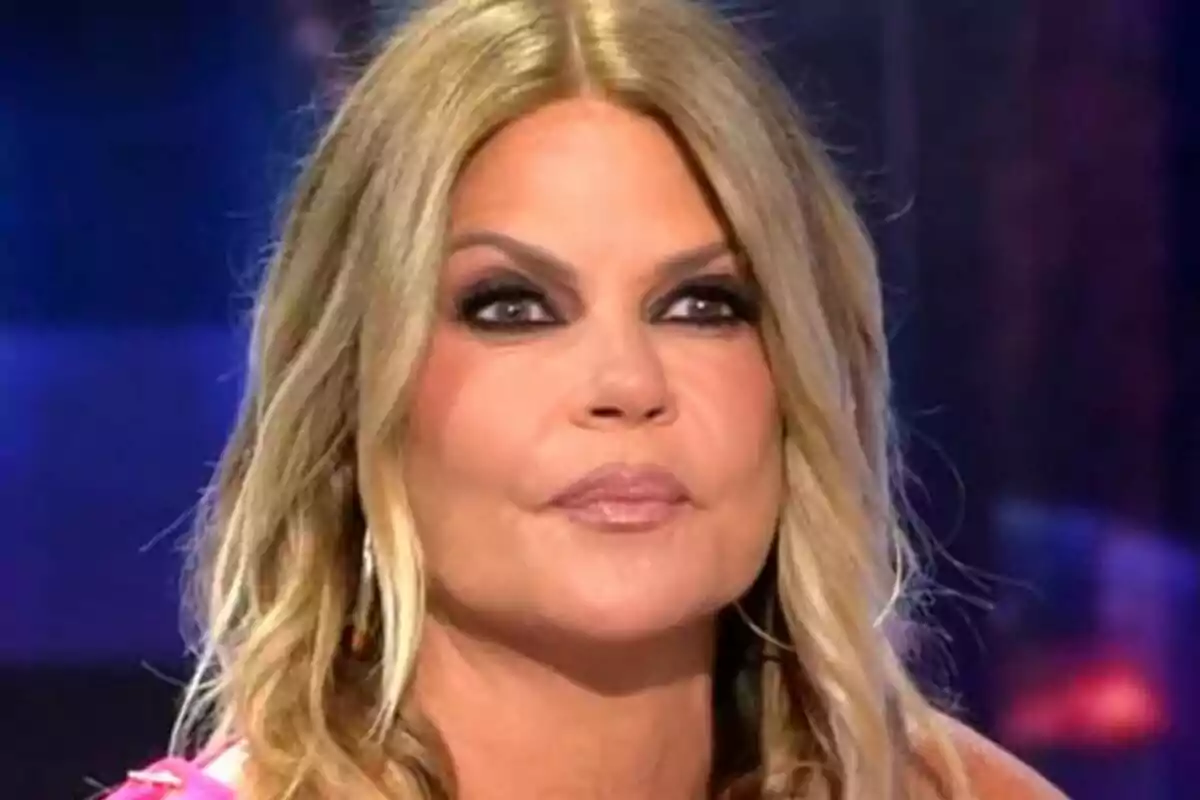 Makoke rubia con maquillaje de ojos oscuro y expresión seria en un entorno de estudio televisivo en De Viernes