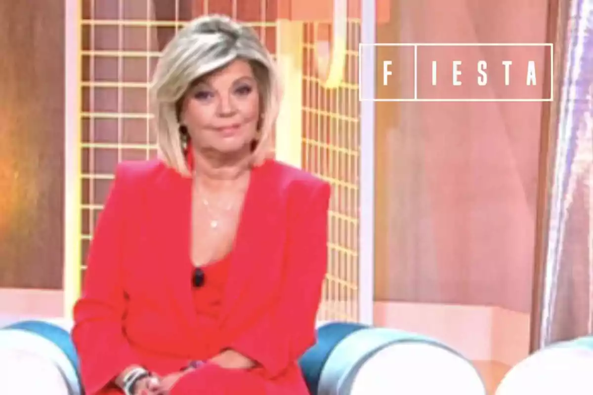 Terelu Campos amb vestit vermell asseguda en un plató de televisió amb el logotip de Fiesta al fons