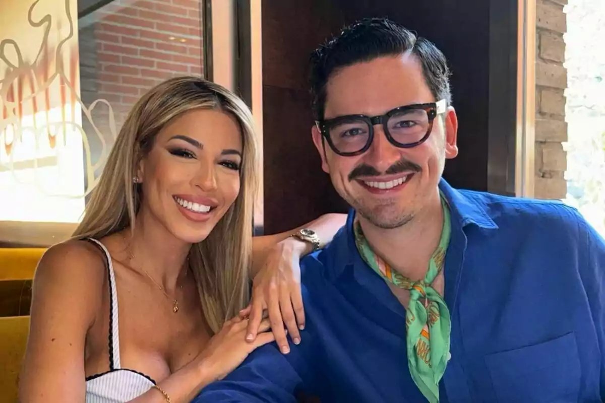 Una dona i un home somriuen mentre posen junts en un restaurant Una dona i un home somriuen mentre posen junts en un restaurant
