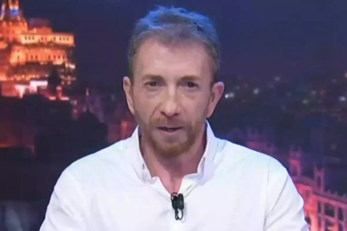 Pablo Motos de cabello corto y barba rojiza vistiendo camisa blanca frente a un fondo urbano iluminado por la noche en El Hormiguero