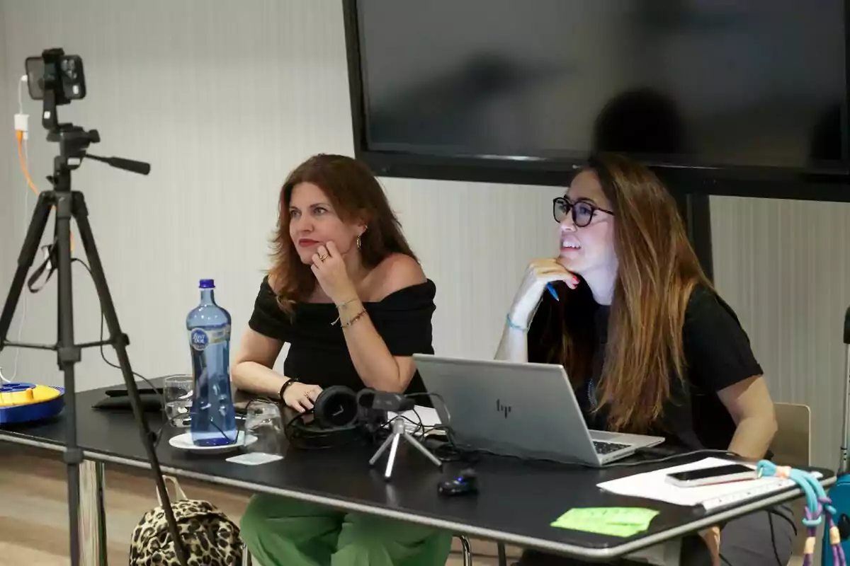 Teresa Colomina junto a otra mujer sentadas en una mesa frente a una laptop y una cámara, participando en el casting de Gran Hermano en un entorno de oficina Teresa Colomina junto a otra mujer sentadas en una mesa frente a una laptop y una cámara, participando en el casting de Gran Hermano en un entorno de oficina