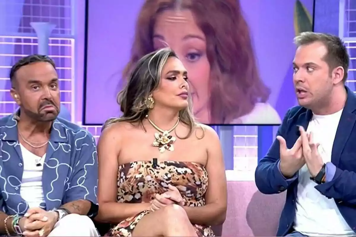 Luis Rollán, Amor Romeira y Saul Ortiz sentadas en un set de Fiesta, dos de ellas escuchan mientras la tercera gesticula con las manos, al fondo se ve una pantalla con el rostro de una mujer. Luis Rollán, Amor Romeira y Saul Ortiz sentadas en un set de Fiesta, dos de ellas escuchan mientras la tercera gesticula con las manos, al fondo se ve una pantalla con el rostro de una mujer.