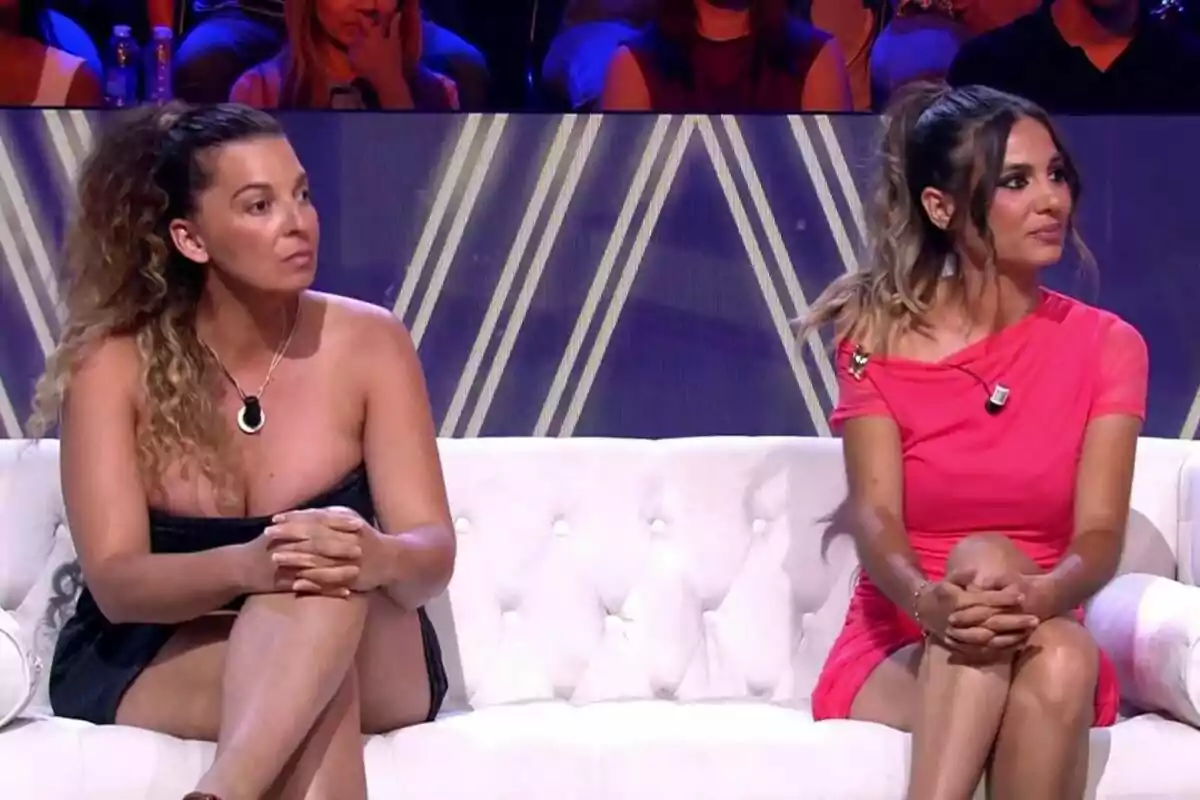 Gema Aldón y Tamara, hermana de Michu, sentadas en un sofá blanco durante De Viernes, una lleva un vestido negro y la otra un vestido rosa, ambas con micrófono de solapa y público al fondo Gema Aldón y Tamara, hermana de Michu, sentadas en un sofá blanco durante De Viernes, una lleva un vestido negro y la otra un vestido rosa, ambas con micrófono de solapa y público al fondo