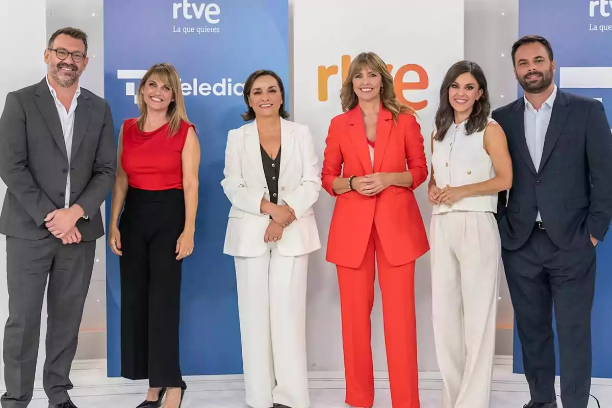 Marc Sala, Lorudes Maldonado, Pepa Bueno, Alejandra Herrand, Alex Barreiro i Lorena Beza posen somrients davant d’un fons amb logotips de RTVE i Telediario, totes vestides de manera formal i elegant.