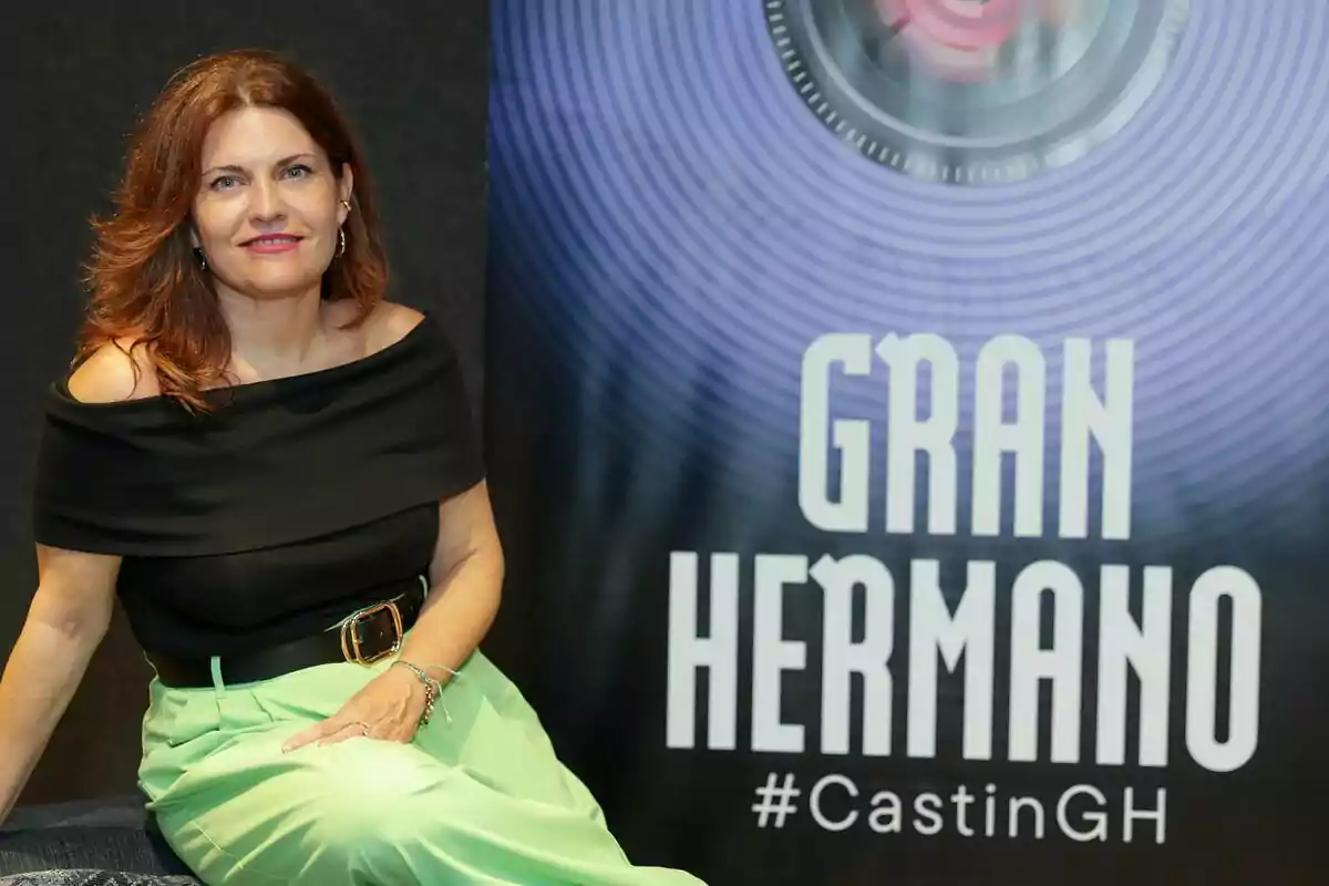 Teresa Colomina de cabello castaño sentada junto a un cartel de Gran Hermano con la etiqueta CastinGH