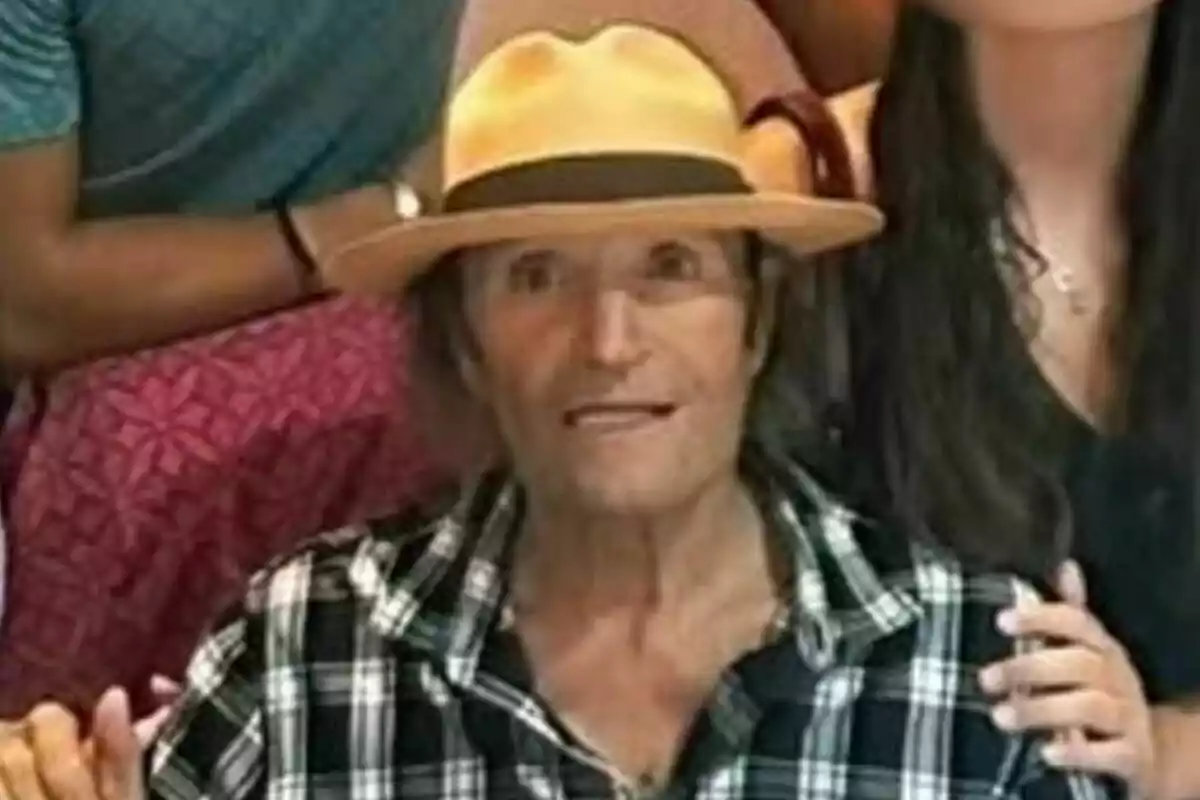 Amador Mohedano amb barret groc i camisa de quadres en una reunió familiar