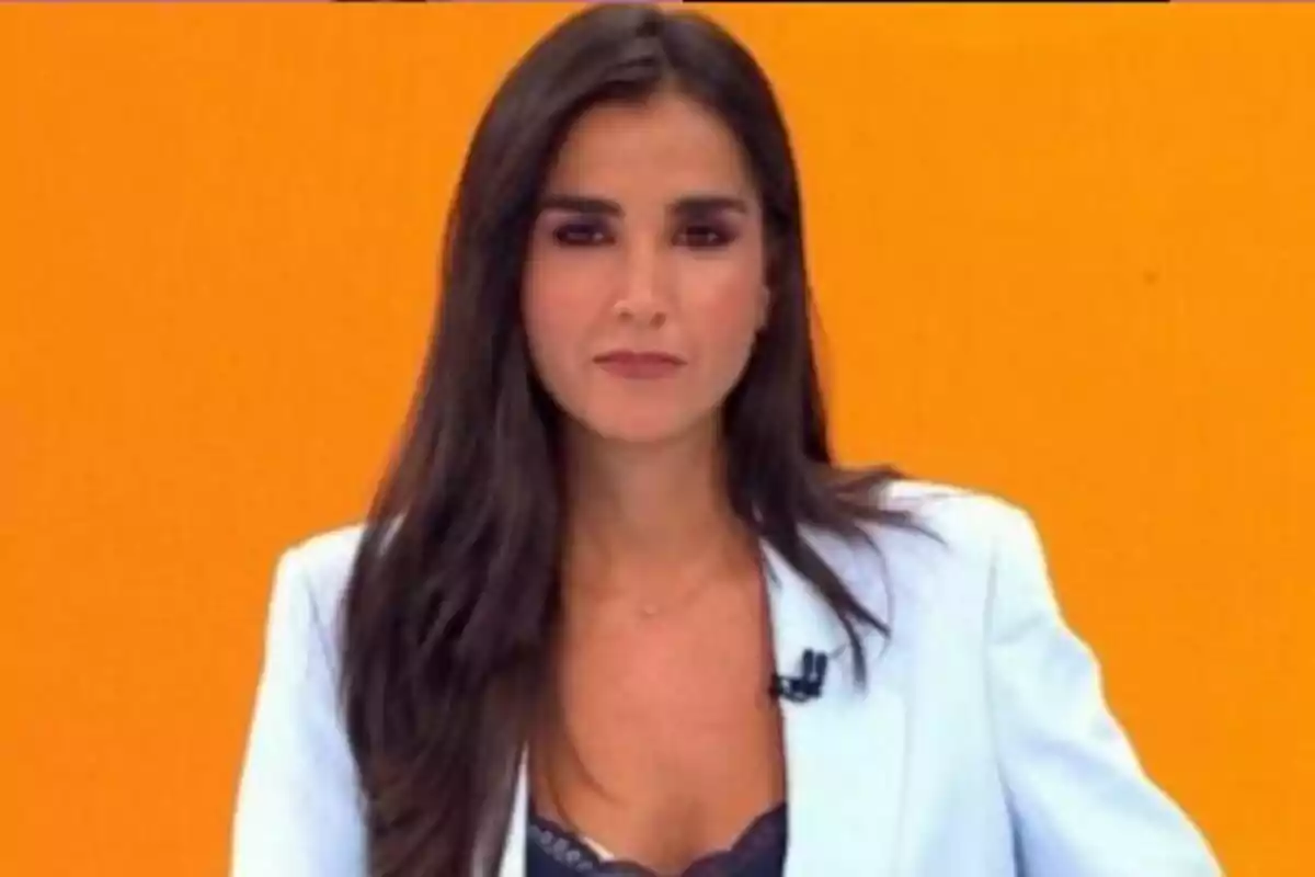 Beatriz Zamorano de cabello largo y oscuro con saco blanco frente a un fondo naranja en laSexta Noticias