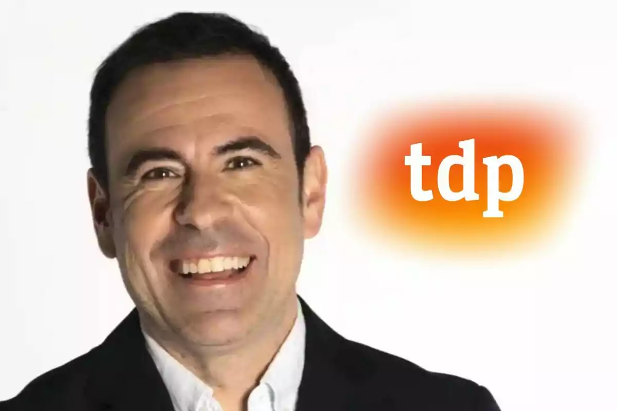 Felipe del Campo sonriente con fondo blanco y el logo de tdp (Teledeporte) en color naranja difuminado a la derecha