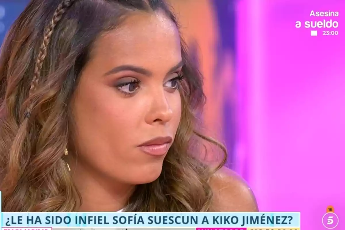 Gloria Camila con expresión seria en un programa de televisión con fondo rosa y texto en pantalla sobre una posible infidelidad Gloria Camila con expresión seria en un programa de televisión con fondo rosa y texto en pantalla sobre una posible infidelidad