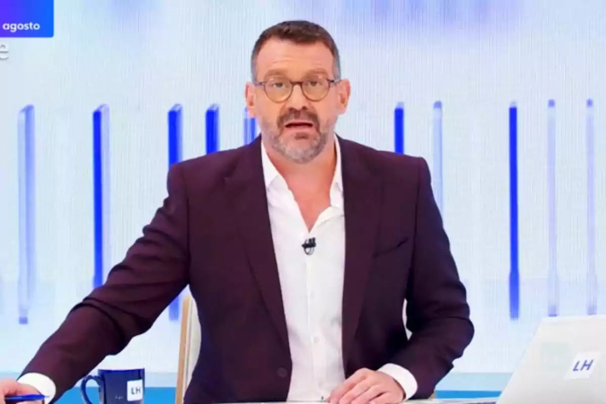 Marc Sala amb ulleres i barba, assegut en un plató de televisió amb fons blau i blanc, porta una jaqueta fosca i camisa blanca, té una tassa i un ordinador portàtil sobre la taula a La Hora de La 1. Marc Sala amb ulleres i barba, assegut en un plató de televisió amb fons blau i blanc, porta una jaqueta fosca i camisa blanca, té una tassa i un ordinador portàtil sobre la taula a La Hora de La 1.