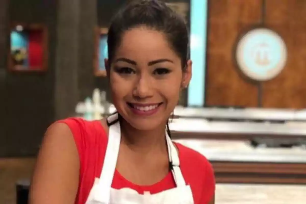 Yanin Campos amb els cabells recollits i una samarreta vermella somriu mentre porta un davantal blanc en una cuina d’un concurs televisiu. Yanin Campos amb els cabells recollits i una samarreta vermella somriu mentre porta un davantal blanc en una cuina d’un concurs televisiu.