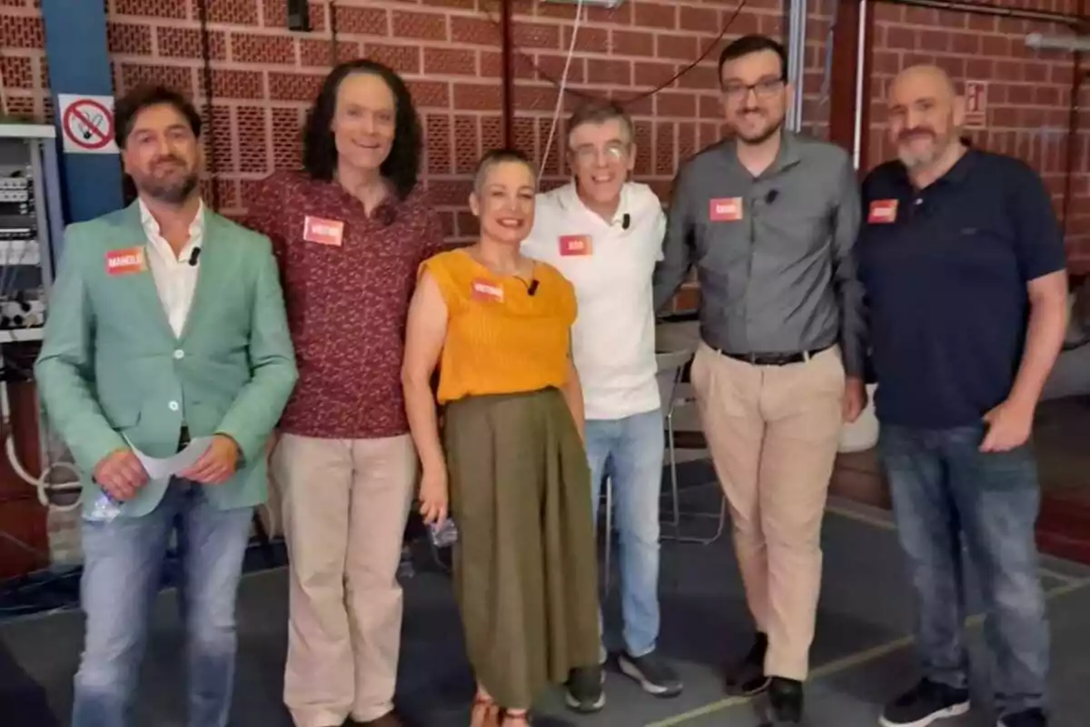Óscar Díaz, David Díaz, Jero Hernández, Victoria Folgueira, Víctor Castro i Manolo Romero posen somrients en un ambient interior amb parets de maó, tots porten micròfon i etiquetes amb els seus noms, alguns sostenen ampolles d’aigua de Saber i Ganar. Óscar Díaz, David Díaz, Jero Hernández, Victoria Folgueira, Víctor Castro i Manolo Romero posen somrients en un ambient interior amb parets de maó, tots porten micròfon i etiquetes amb els seus noms, alguns sostenen ampolles d’aigua de Saber i Ganar.