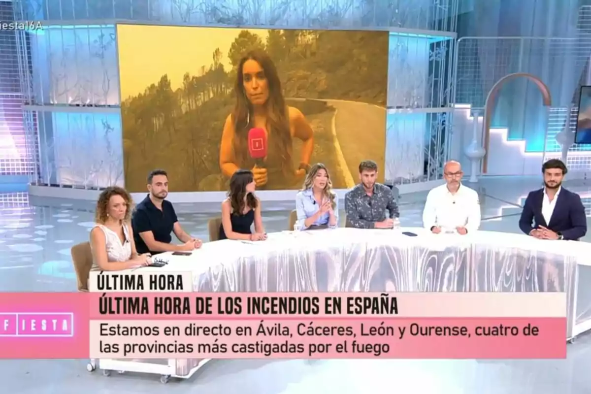 Un grup de presentadors i col·laboradors com Álex Blanquer i César Muñoz d’un programa de Festa estan asseguts en una taula mentre en una pantalla gran apareix una reportera, Arabella Otero, informant des d’una zona afectada per incendis forestals a Espanya. Un grup de presentadors i col·laboradors com Álex Blanquer i César Muñoz d’un programa de Festa estan asseguts en una taula mentre en una pantalla gran apareix una reportera, Arabella Otero, informant des d’una zona afectada per incendis forestals a Espanya.
