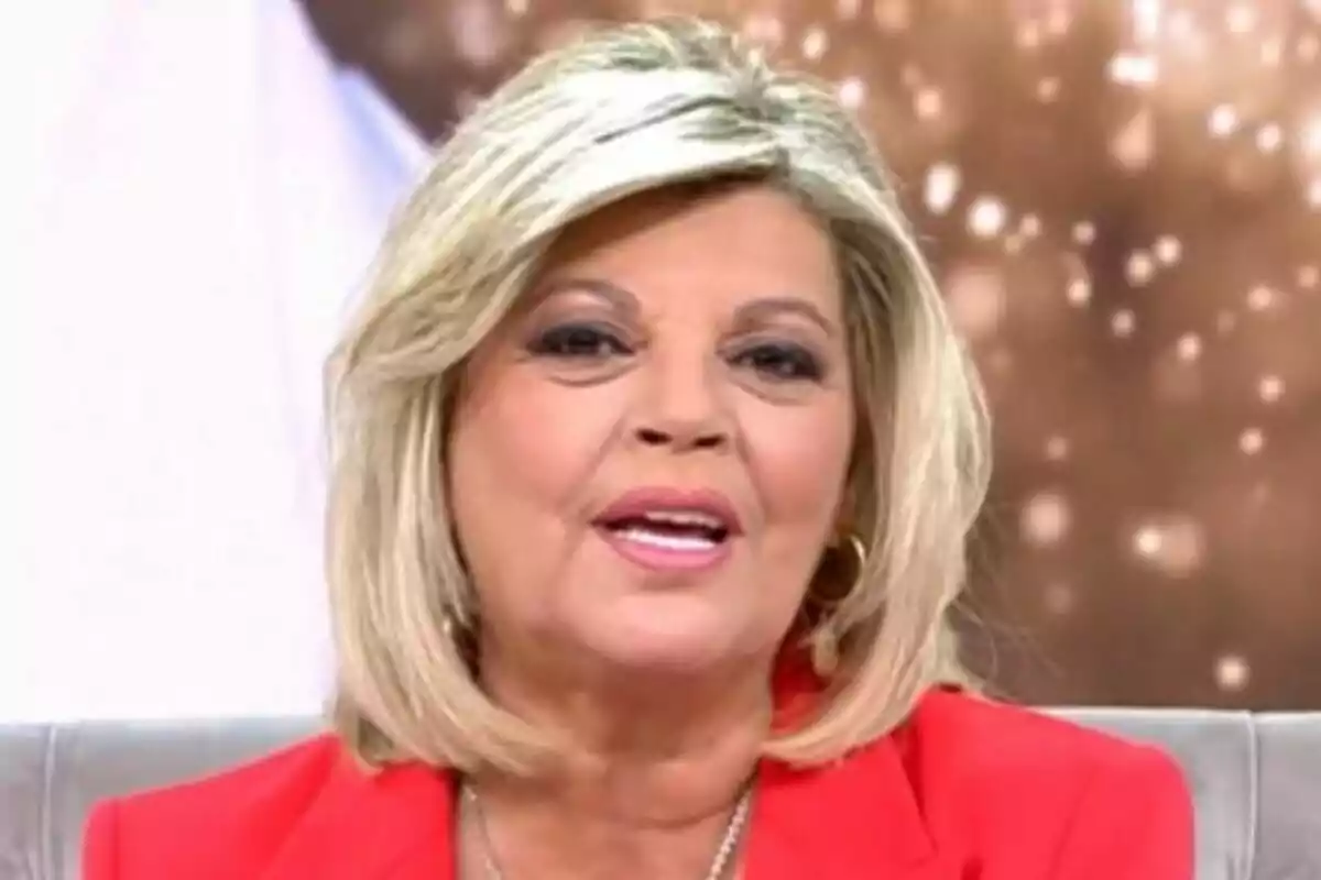 Terelu Campos rossa de cabell curt amb jaqueta vermella asseguda en un plató de Festa
