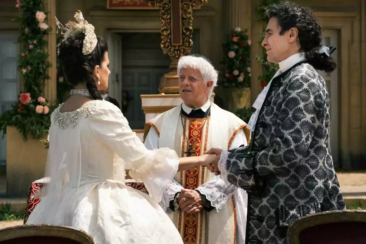 Sabela Arán y José Manuel Seda vestida con trajes de época se toma de las manos frente a un sacerdote durante una ceremonia al aire libre con decoraciones florales en Valle Salvaje. Sabela Arán y José Manuel Seda vestida con trajes de época se toma de las manos frente a un sacerdote durante una ceremonia al aire libre con decoraciones florales en Valle Salvaje.