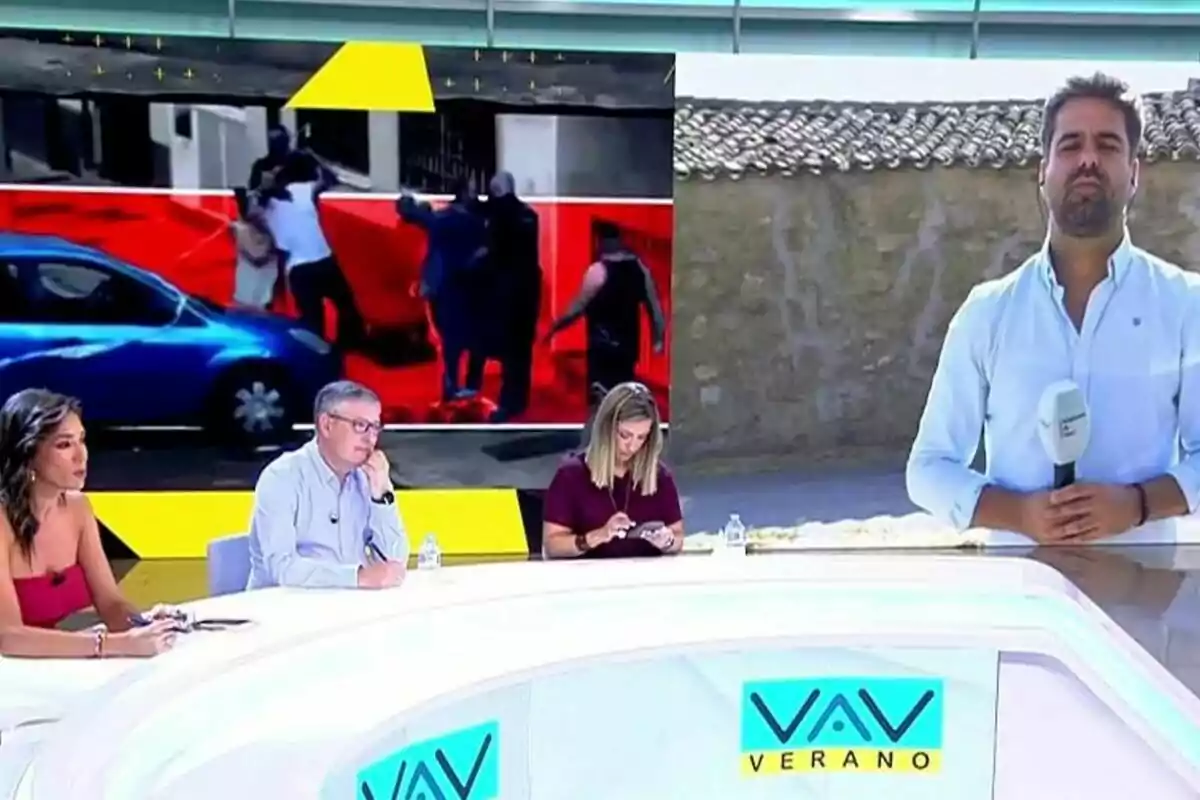Vamos a ver con Patricia Pardo y dos colaboradores sentados en una mesa blanca y un reportero de pie al aire libre sosteniendo un micrófono, mientras en una pantalla grande se muestra una imagen de un incidente en la calle. Vamos a ver con Patricia Pardo y dos colaboradores sentados en una mesa blanca y un reportero de pie al aire libre sosteniendo un micrófono, mientras en una pantalla grande se muestra una imagen de un incidente en la calle.