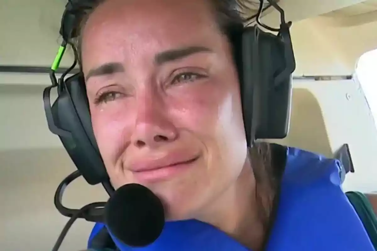 Adara Molinero plorant amb auriculars i armilla blava dins d’una cabina d’avió a Supervivientes All Stars