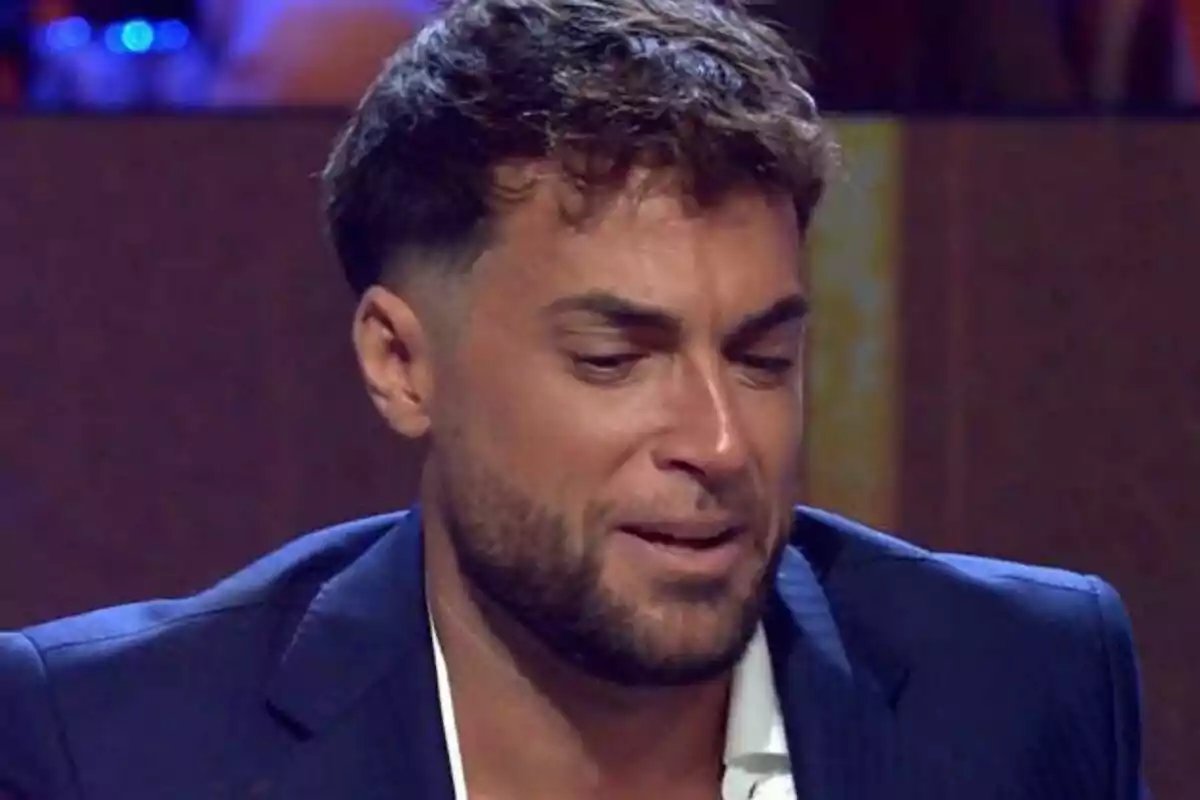 Montoya joven con barba y cabello corto en De Viernes luce emocionado o triste mientras lleva puesto un saco azul Montoya joven con barba y cabello corto en De Viernes luce emocionado o triste mientras lleva puesto un saco azul