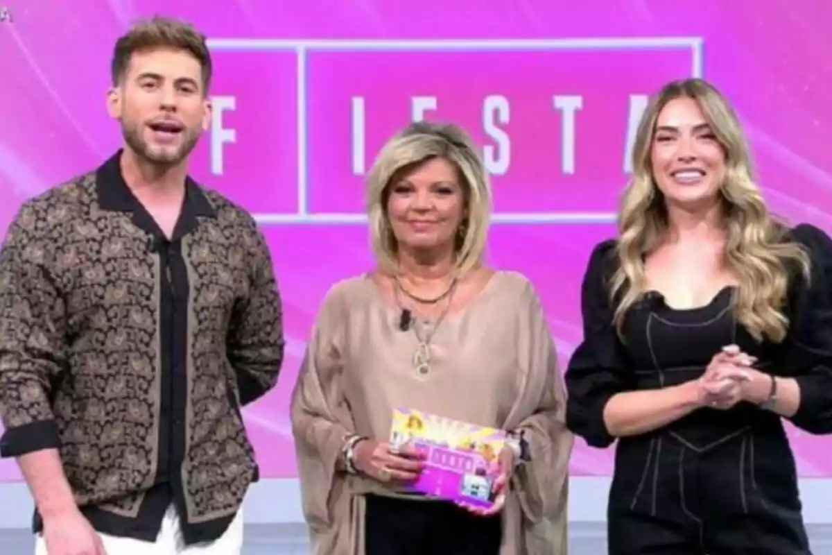 César Muñoz, Terelu Campos y Álex Blanquer posan sonrientes en un set con fondo rosa y la palabra FIESTA escrita detrás de ellos