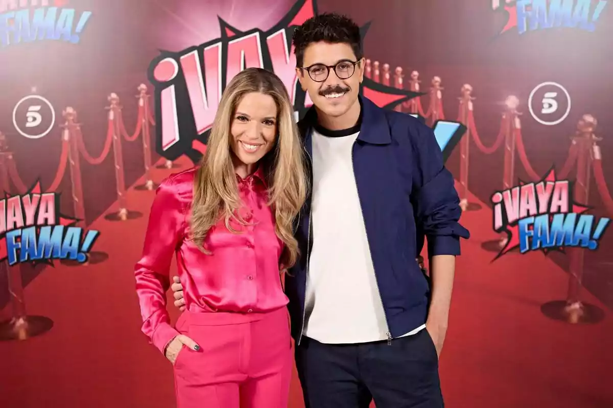 Cristina Lasvignes i Fran Ramírez posen somrients davant d’un fons vermell amb el logotip de ¡Vaya Fama! i catifa vermella. Cristina Lasvignes i Fran Ramírez posen somrients davant d’un fons vermell amb el logotip de ¡Vaya Fama! i catifa vermella.