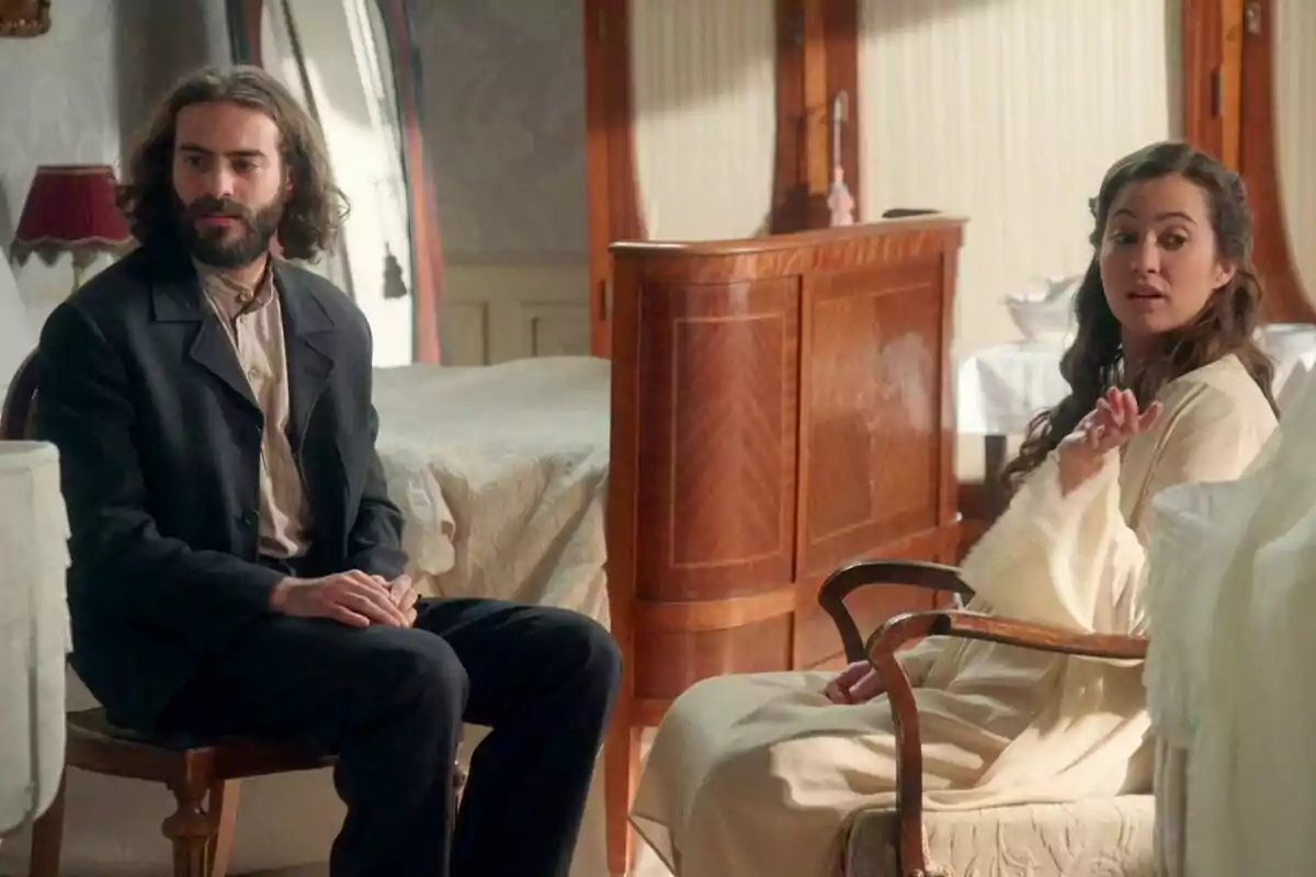 Ibrahim Al Shami y Carmen Asecas sentadas en una habitación con muebles de madera, una de ellas parece estar hablando mientras la otra escucha atentamente en La Promesa. Ibrahim Al Shami y Carmen Asecas sentadas en una habitación con muebles de madera, una de ellas parece estar hablando mientras la otra escucha atentamente en La Promesa.