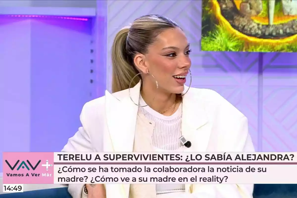 Alejandra Rubio con coleta y pendientes grandes está sentada en Vamos a ver, vestida con un blazer blanco, mientras participa en un programa llamado Alejandra Rubio con coleta y pendientes grandes está sentada en Vamos a ver, vestida con un blazer blanco, mientras participa en un programa llamado