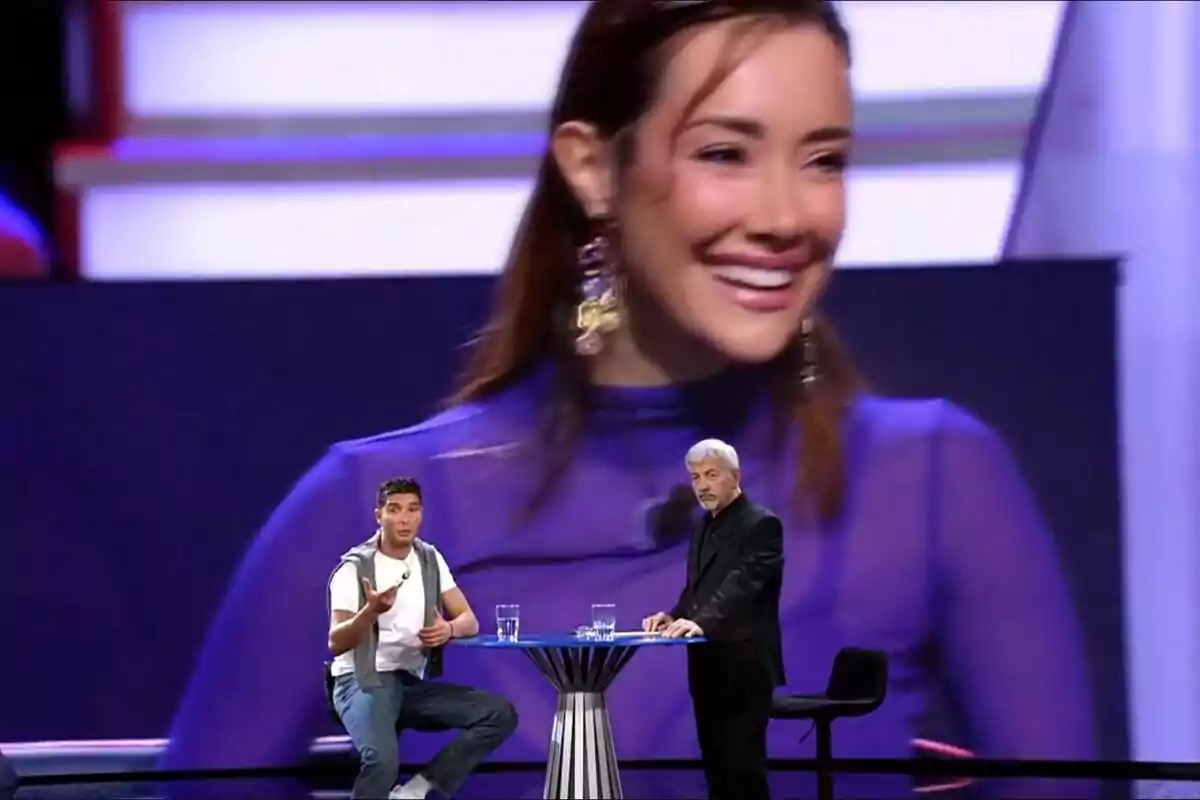 Álex Ghita y Carlos Sobera están en el plató de GH DÚO frente a una gran pantalla que muestra a Adara Molinero sonriendo. Álex Ghita y Carlos Sobera están en el plató de GH DÚO frente a una gran pantalla que muestra a Adara Molinero sonriendo.