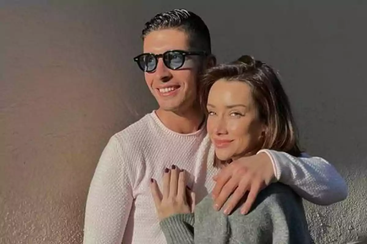 Una parella, formada per Adara Molinero i Alex Ghita, somrient posant junts amb llum natural.