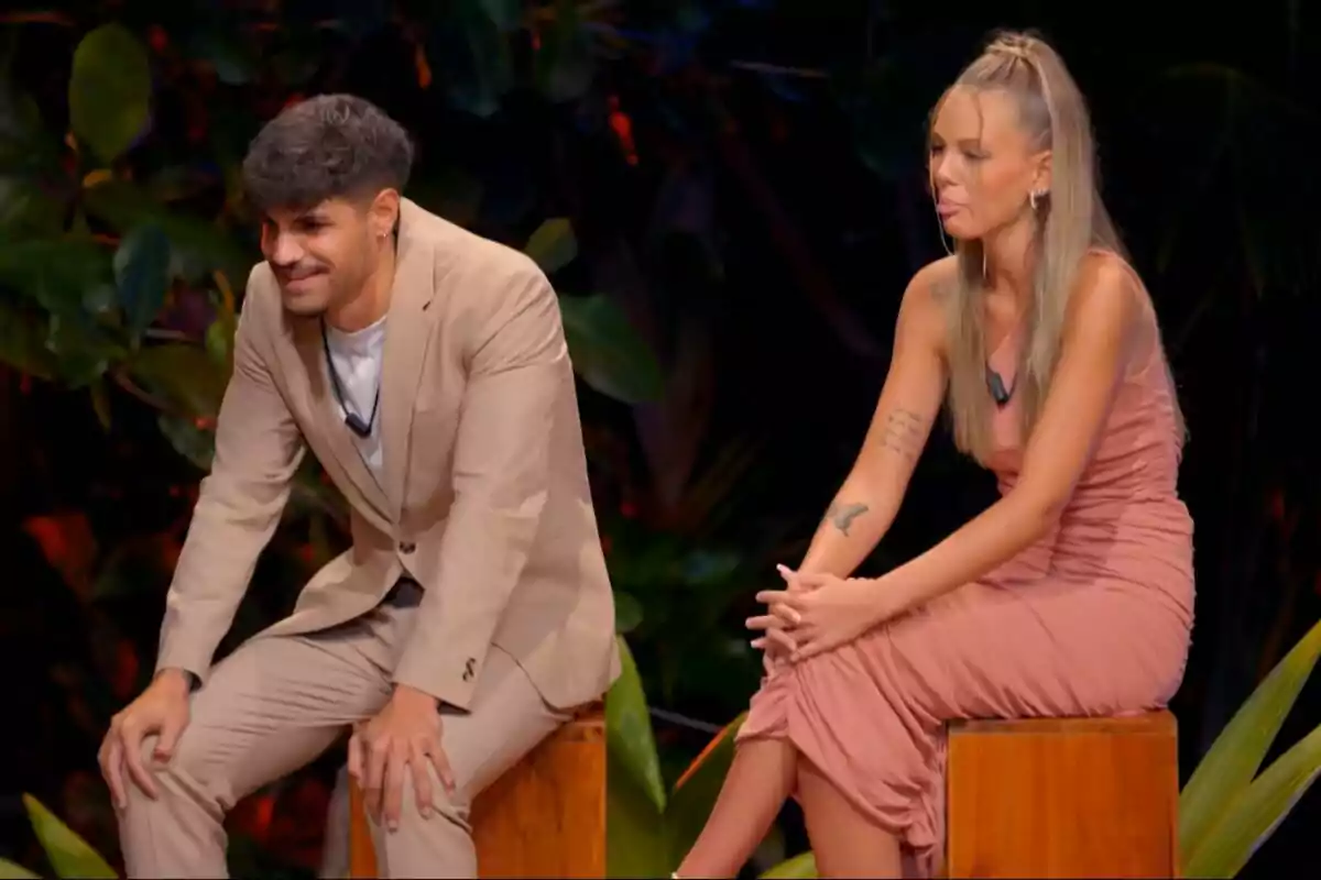 Álvaro y Alba sentadas en taburetes de madera en un entorno con vegetación, una de ellas lleva un traje beige y la otra un vestido rosa en La Isla de las Tentaciones. Álvaro y Alba sentadas en taburetes de madera en un entorno con vegetación, una de ellas lleva un traje beige y la otra un vestido rosa en La Isla de las Tentaciones.