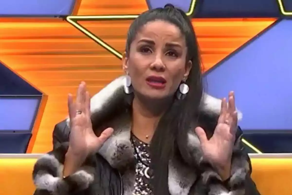 Ana Herminia amb expressió emocional en un set de televisió amb fons d'estrelles taronges i blaves a GH DÚO.
