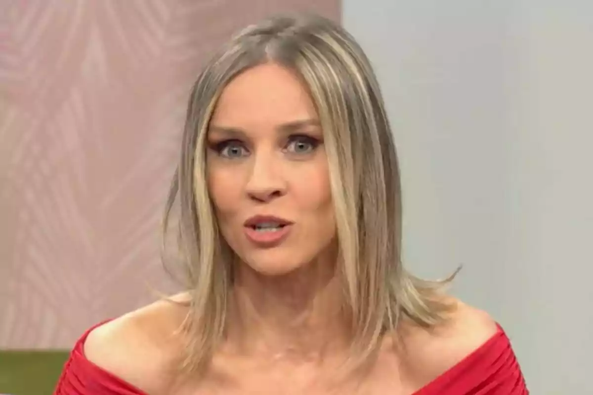 Ana Prada con cabello rubio y lacio lleva un vestido rojo y está hablando en un entorno interior en D Corazón. Ana Prada con cabello rubio y lacio lleva un vestido rojo y está hablando en un entorno interior en D Corazón.