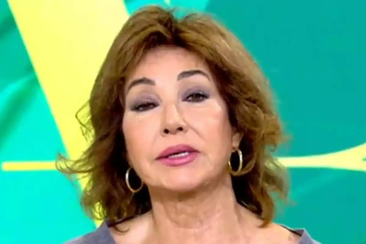 Ana Rosa Quintana amb cabell castany i arracades daurades davant d'un fons verd i groc a El Programa de Ana Rosa. Ana Rosa Quintana amb cabell castany i arracades daurades davant d'un fons verd i groc a El Programa de Ana Rosa.