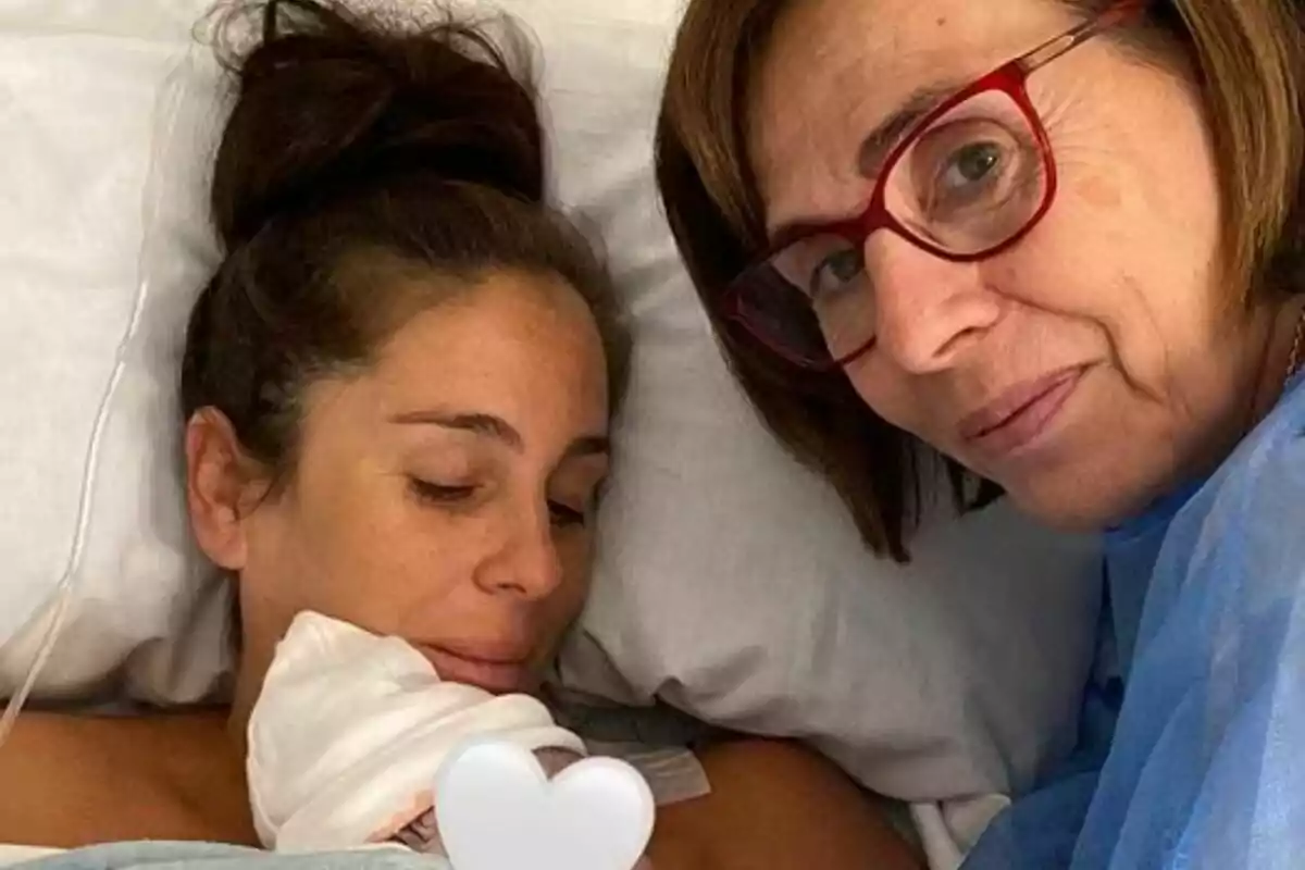 Anabel Pantoja en un llit d'hospital sosté un nadó mentre la seva mare Merchi amb ulleres somriu a la càmera. Anabel Pantoja en un llit d'hospital sosté un nadó mentre la seva mare Merchi amb ulleres somriu a la càmera.