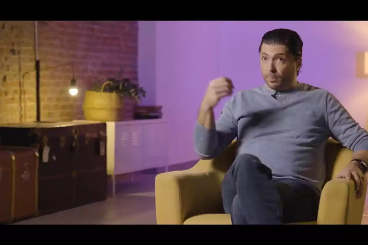Ángel Cristo, assegut en una butaca groga en una habitació amb parets de maó i llum tènue, parlant sobre la seva mare a '¡De Viernes!' Ángel Cristo, assegut en una butaca groga en una habitació amb parets de maó i llum tènue, parlant sobre la seva mare a '¡De Viernes!'