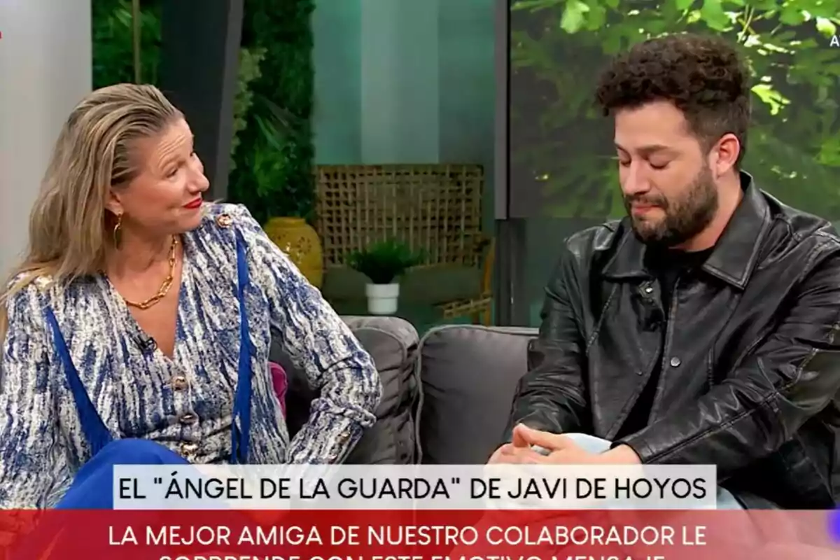 Dos personas sentadas en un sofá durante D Corazón, Anne Igartiburu con una blusa azul y Javi de Hoyos con chaqueta de cuero negro, con un texto en la parte inferior que menciona un mensaje emotivo. Dos personas sentadas en un sofá durante D Corazón, Anne Igartiburu con una blusa azul y Javi de Hoyos con chaqueta de cuero negro, con un texto en la parte inferior que menciona un mensaje emotivo.
